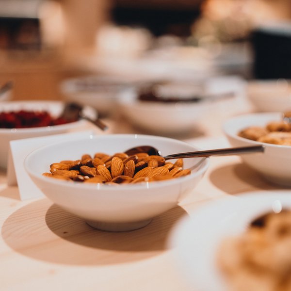 Sensoria Dolomites – Luxury for the Soul White bowls with almonds and dried fruits on wooden table