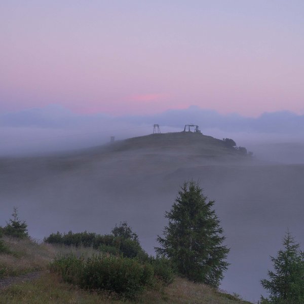 Sensoria Dolomites – Luxury for the Soul Foggy hill with trees and ski lift in soft morning light