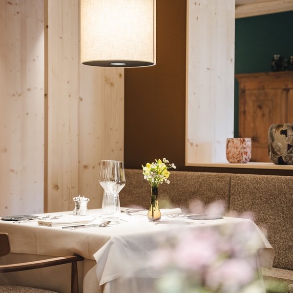 Sensoria Dolomites – Luxury for the Soul Set dining table with flowers in a modern restaurant