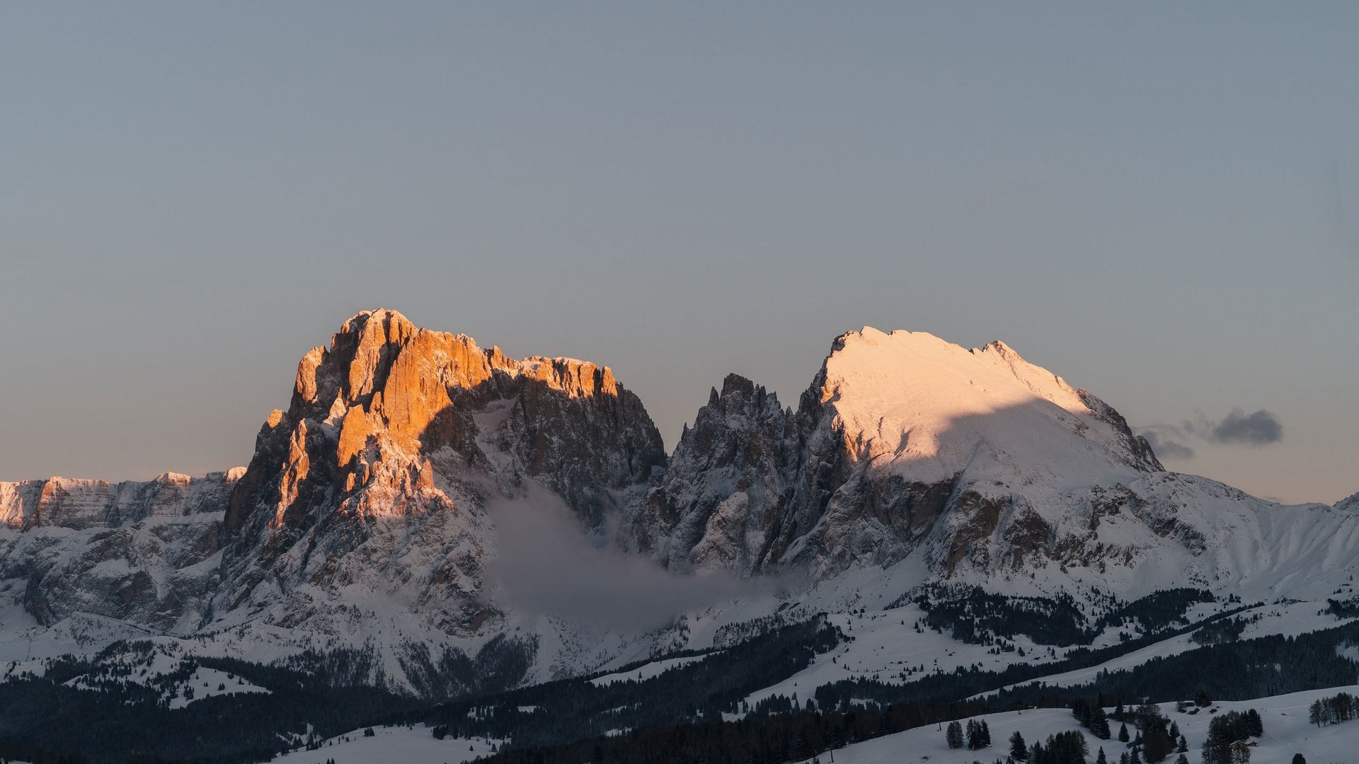 Sensoria Dolomites. Kraftort. Winterzauber. Schneebedeckte Berggipfel im Abendlicht mit klarem Himmel