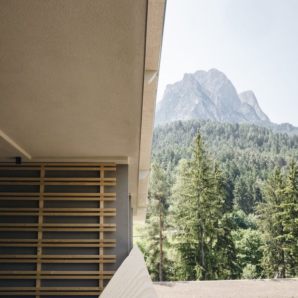 Sensoria Dolomites – Luxury for the Soul Balcony with wooden railing overlooking forest and mountain in the background