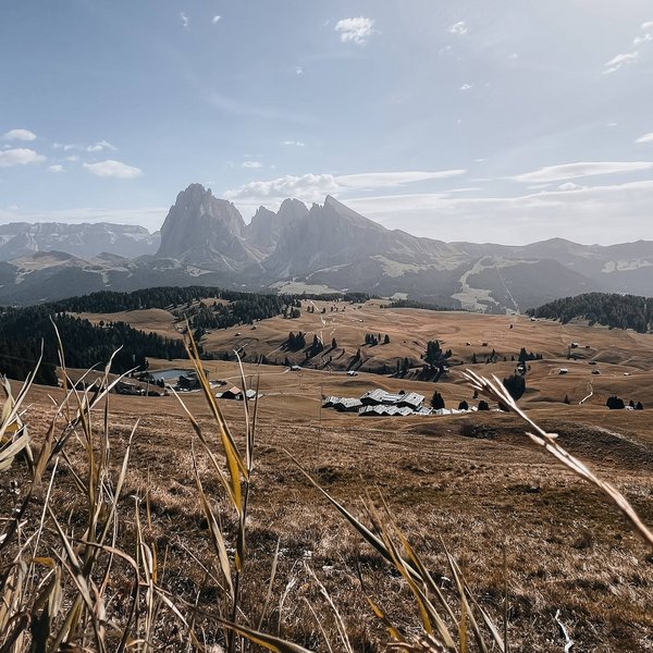 Sensoria Dolomites – Luxury for the Soul Blick auf Berge und Tal mit Feldern und Holzhäusern unter klarem Himmel