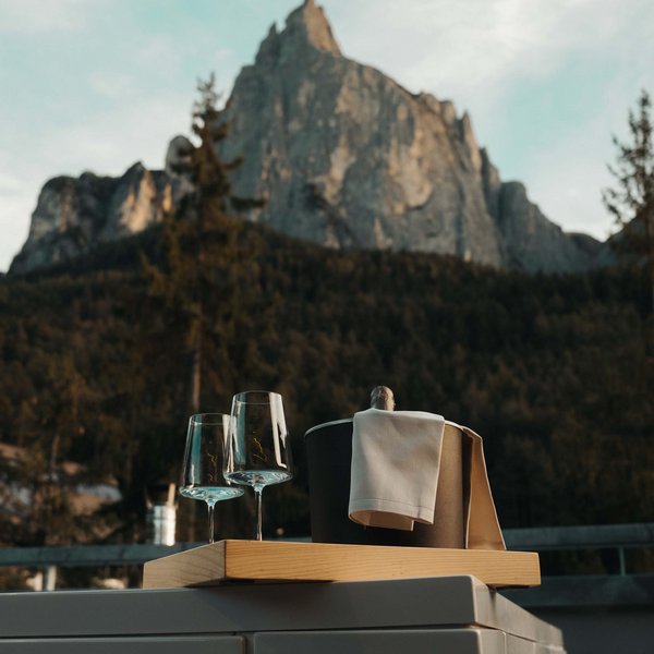 Sensoria Dolomites – Luxury for the Soul Weingläser und Champagner in Eiskübel vor Berglandschaft bei Sonnenuntergang