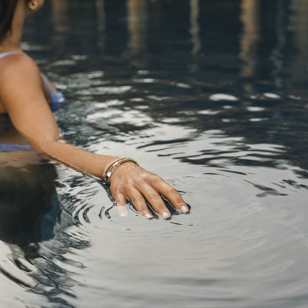Sensoria Dolomites – Luxury for the Soul Woman touching the water surface in a pool