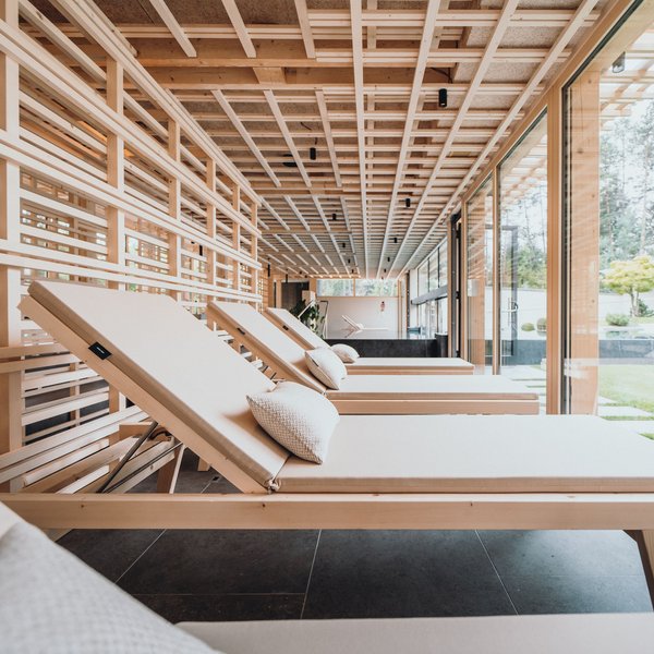 Sensoria Dolomites – Luxury for the Soul Interior view of modern lounge chairs with cushions near large glass windows