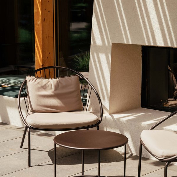 Sensoria Dolomites – Luxury for the Soul Modern outdoor seating area with chairs and small table in sunlight