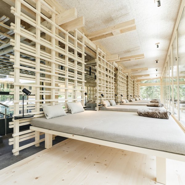 Sensoria Dolomites – Luxury for the Soul Bright lounge beds with wooden partitions and large windows in modern spa area