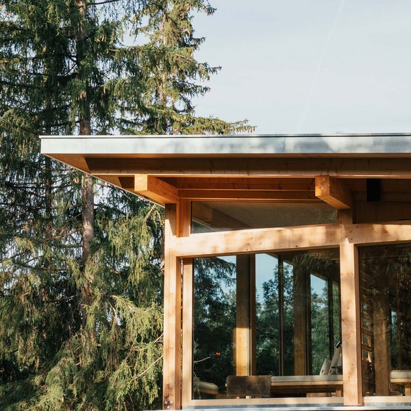 Sensoria Dolomites – Luxury for the Soul Wooden house with large windows beside tall pine trees in forest