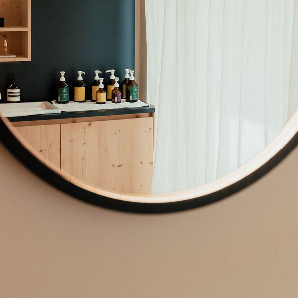 Sensoria Dolomites – Luxury for the Soul Round mirror reflecting counter with soap and skincare bottles
