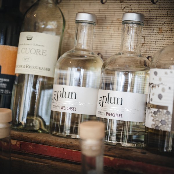 Sensoria Dolomites – Luxury for the Soul Several bottles with clear and dark liquids on a shelf