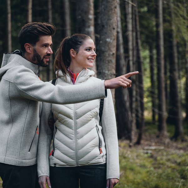 Sensoria Dolomites – Luxury for the Soul Couple in forest, man pointing at something, both wearing light outdoor clothing