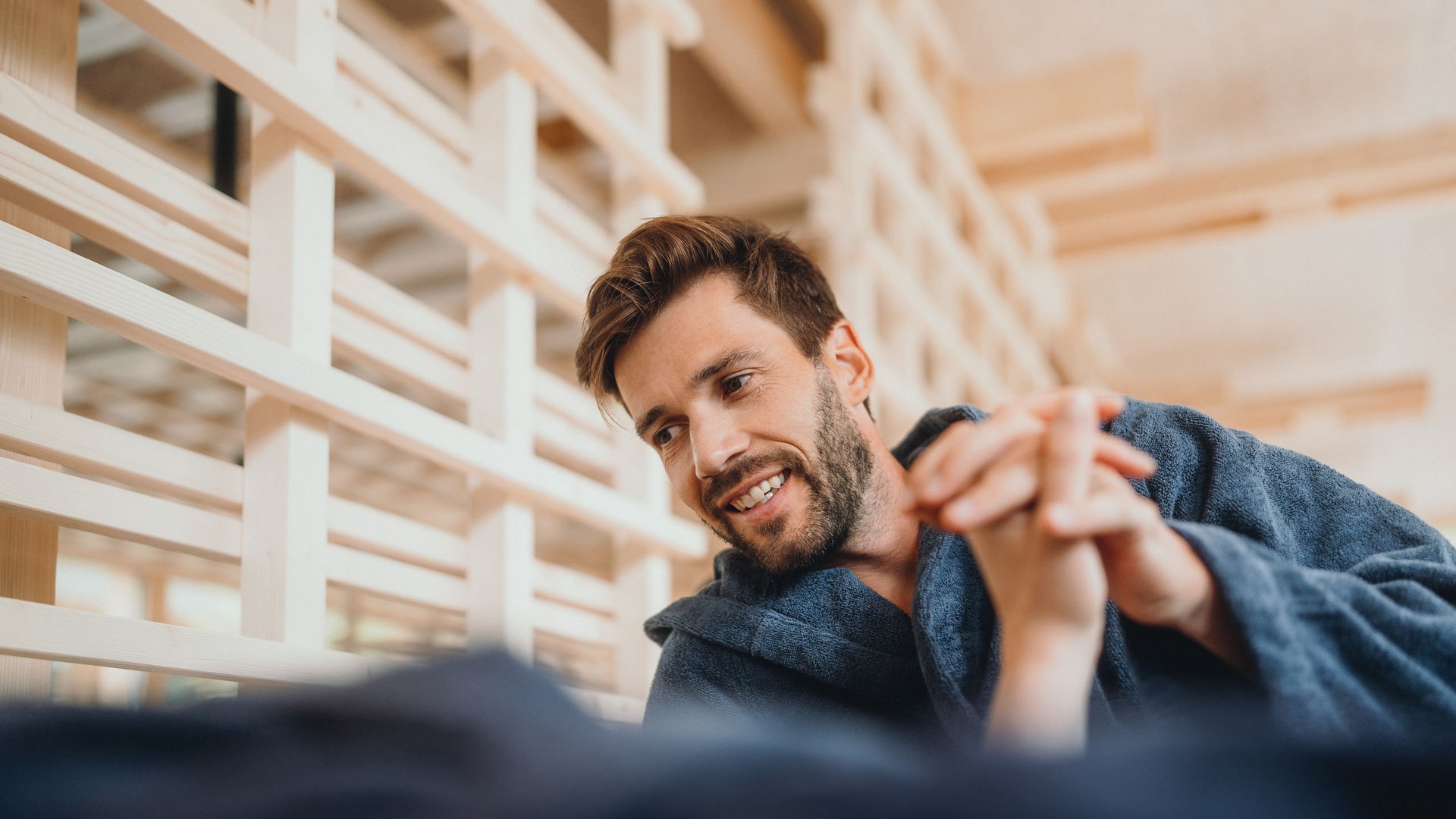 Sensoria Dolomites – Luxury for the Soul Man in bathrobe smiling and holding hands, relaxed atmosphere