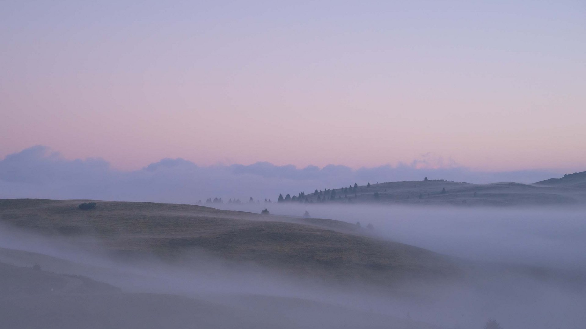 Sensoria Dolomites – Luxury for the Soul Mist rolling over gentle hills at twilight with a pink sky
