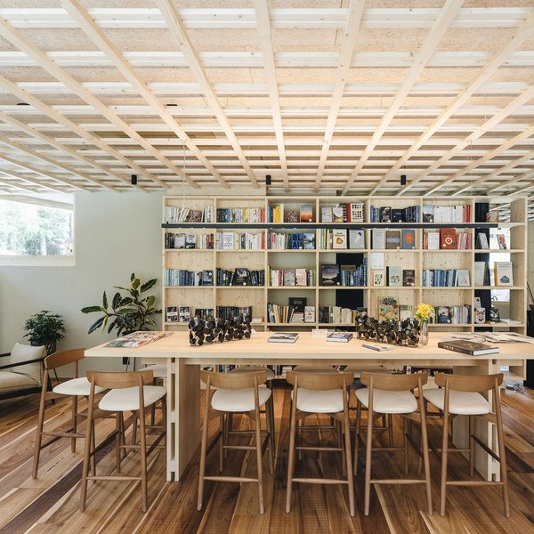 Sensoria Dolomites – Luxury for the Soul Bright reading room interior with large wooden table and bookshelf in background